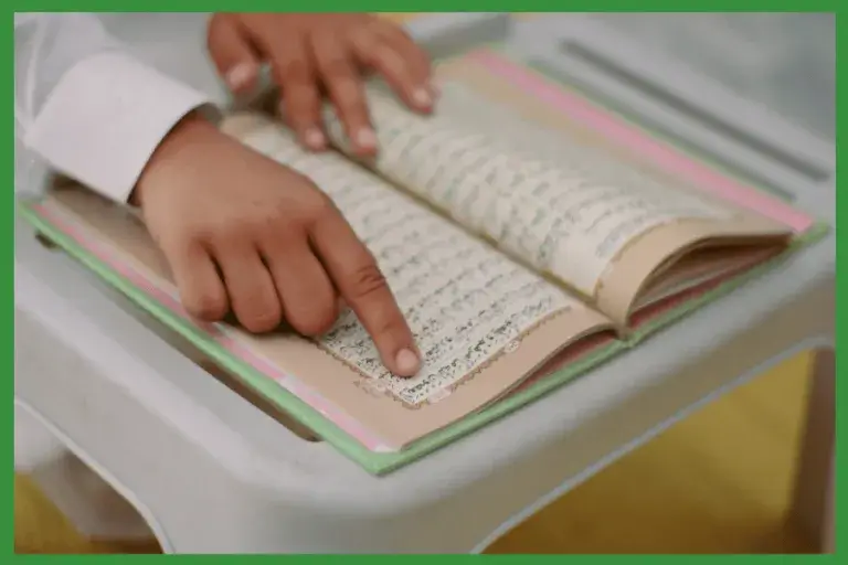 Child learning to read the Quran from an open Mushaf